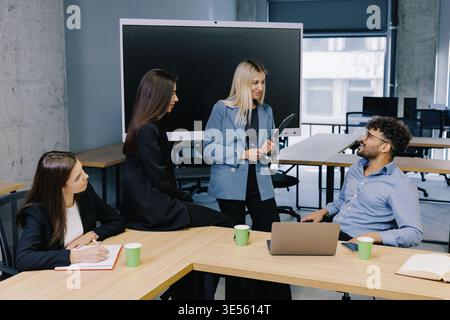Verschiedene Geschäftsleute diskutieren und Ideen während eines informellen Meetings in einem modernen Großraumbüro Stockfoto