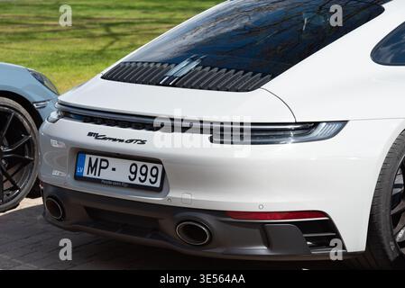 Valmiera, Lettland-26. April 2025-Ein weißer Porsche 911 Carrera GTS mit lettischen Kennzeichen, die im Freien geparkt sind, präsentiert sein elegantes Heckdesign und Dual Stockfoto