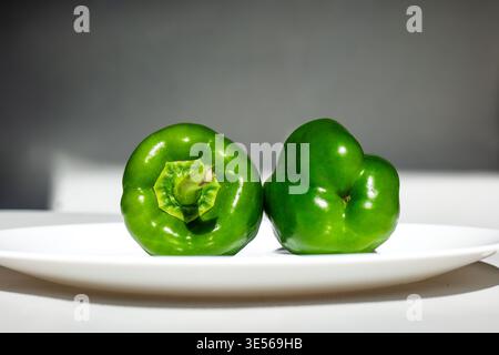 Gemischtes frisches Bio-Gemüse, einschließlich rote Tomaten, grüne Paprika und Orangenmohröhren, auf weißen Tellern und Holzschneidebrettern, M Stockfoto