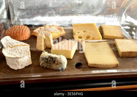 Authentische französische Käseplatte mit verschiedenen Gourmet-Sorten auf Holztablett. Stockfoto