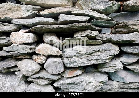 Traditionelles Trockenmauerwerk mit natürlichen Berggranit- und Schieferstrukturen im Detail. St. Gervais. Frankreich. Stockfoto