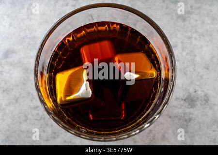 Alkoholisches Getränk mit kühlenden Stahlwürfeln im Hintergrund Stockfoto