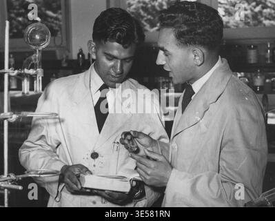 Zwei Kadetten der Royal Pakistan Air Force, die jetzt am RAAF College Point Cook studieren, diskutieren ein Experiment im Wissenschaftslabor. August 1954. Stockfoto