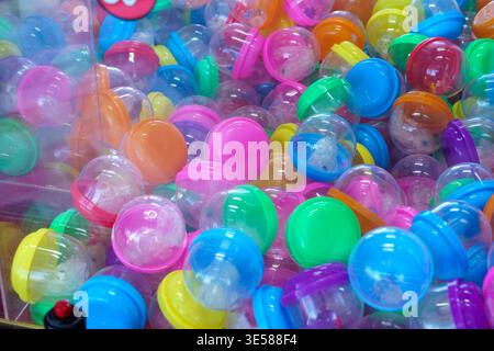 Bunte Plastikkapseln in Klauenautomat-Verkaufsspiel mit Preisen und Spielzeug Stockfoto