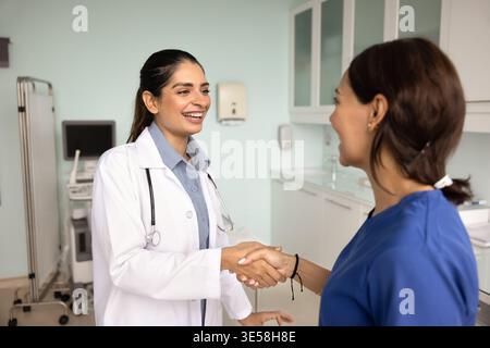Ärztinnen grüßen sich gegenseitig mit Handschlag in der Klinik Stockfoto