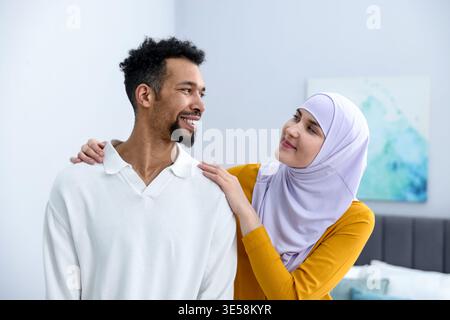 Glückliches muslimisches Paar, das sich zu Hause ansieht Stockfoto