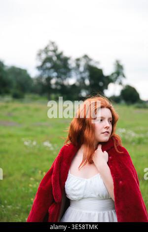 Rothaarige Frau, die auf grünem Feld steht Stockfoto