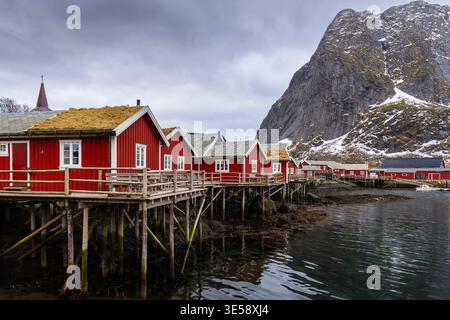 Blick auf das typische rorbuer in reine in Richtung Reinebringen im Winter, Lofoten Inseln, Norwegen. Stockfoto