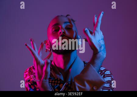 Retro Wave oder Synthesizer Wave Portrait stilvolle ernsthafte afroamerikanische Tänzerinnen-Studio-Shooting. High Fashion männliches Model tanzen in bunten hellen Neonlichtern. Stockfoto