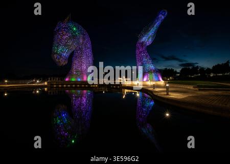 Die Kelpies beleuchtet nachts mit farbenfroher Beleuchtung im Helix Park, Falkirk, Schottland. Stockfoto
