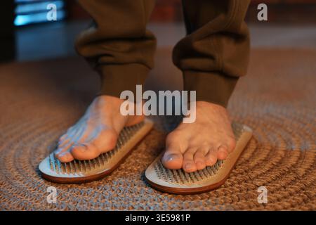 Mann, der zu Hause auf Sadhu-Brettern steht, Nahaufnahme Stockfoto