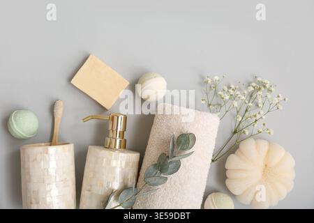 Set aus Badeutensilien und Zigeunerblumen auf grauem Hintergrund Stockfoto
