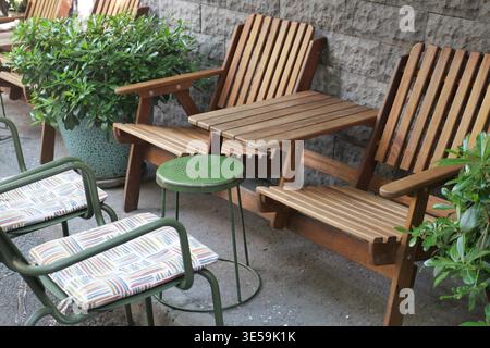 Holzstühle und kleiner Tisch in der Nähe von Grün im Außenbereich Stockfoto