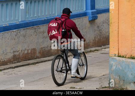 Ein junger Mann auf einem Fahrrad durch eine der Straßen von Ciego de Avila in Kuba Stockfoto