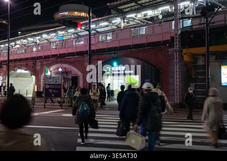 Tokio, Japan - 22. Februar 2026: Menschen nutzen die Zebraüberquerung, um am Abend den Bahnhof Yurakucho Yokocho zu verlassen. Stockfoto