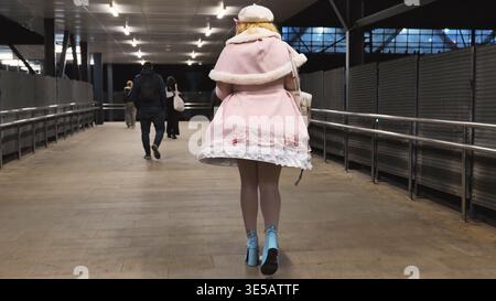 Frau in blauen Plateauschuhen, die auf urbanem Pflaster, Mode- und Stilkonzept laufen Stockfoto