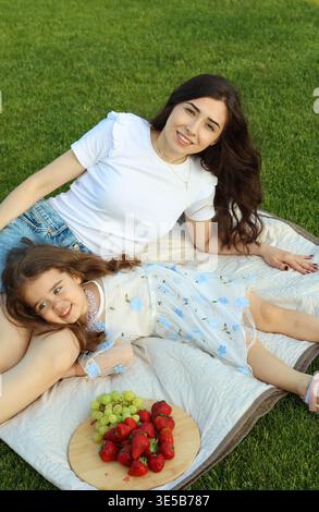 Entspanntes Geburtstagsfest Im Freien, Bei Dem Mutter Und Tochter Früchte Und Freudige Momente Teilen Stockfoto