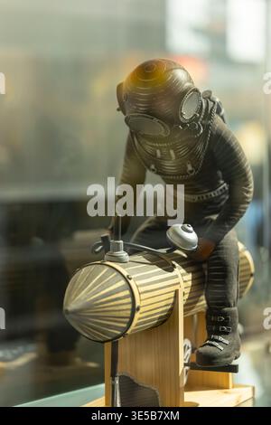 Tiefseetaucher Figur, die ein Retro-U-Boot betreibt, symbolisiert Entdeckungen und Abenteuer Stockfoto
