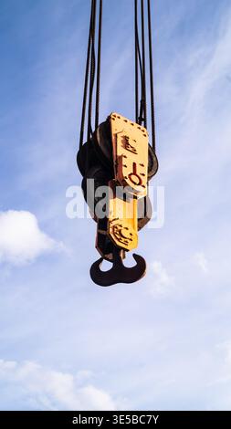 Hochleistungs-Kranhaken und Riemenscheibenblock hängen am blauen Himmel, Bauindustrie Stockfoto