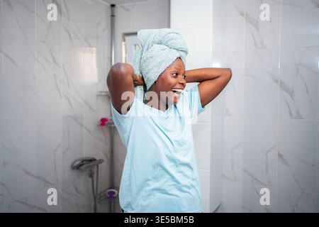 Glückliche junge erwachsene Frau, die sich die Selbstpflege-Morgenroutine genießt Stockfoto