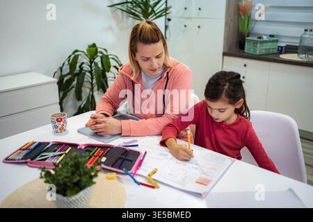 Mutter und Tochter lernen zu Hause und machen Hausaufgaben Stockfoto