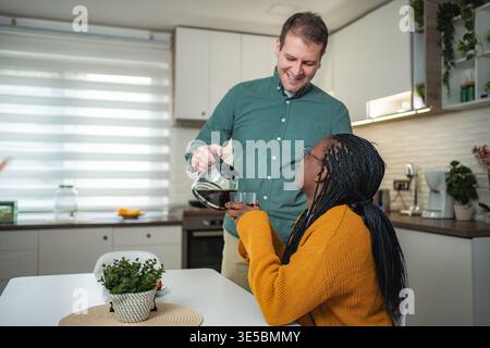 Glückliches Paar genießt Morgenkaffee zusammen in der Küche Stockfoto