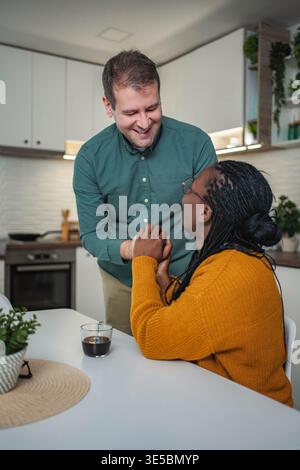Multiethnisches Paar verbindet Hände, lächelt in der Küche Stockfoto