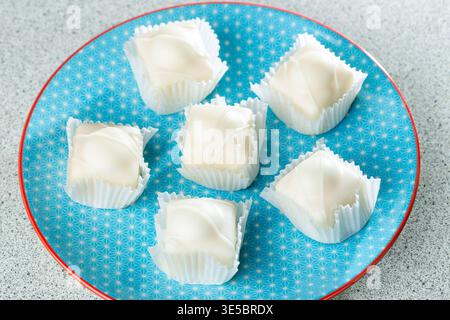 Sechs Mr. Kipling Frosty auf einem blauen Teller. Stockfoto