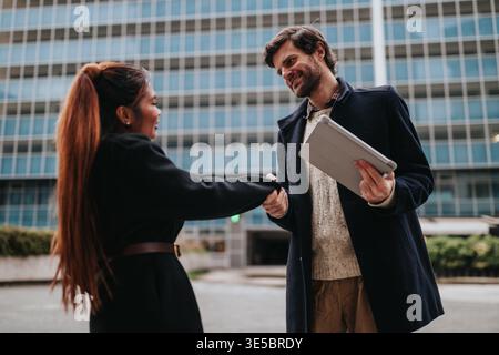 Geschäftspartner schütteln sich nach einem erfolgreichen Meeting vor einem Firmenbüro die Hände Stockfoto