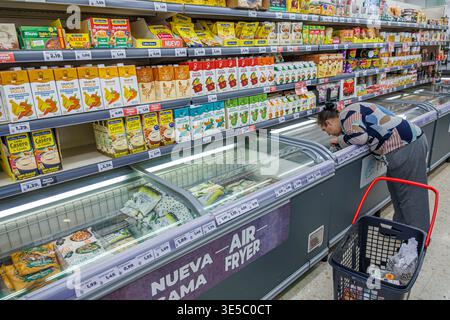 Malaga Spanien, Andalusien, El Molinillo Capuchinos Nachbarschaft, Supermarkt innen Tiefkühltruhe Gang Frau Erwachsene weibliche Käuferin Biegen Auswahl Stockfoto