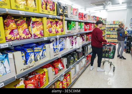 Malaga Spanien, Andalusien, El Molinillo Capuchinos Nachbarschaft, Supermarkt Inneres Snack Gang Erwachsener Mann männlicher Einkäufer schiebt Warenkorb durchsuchen Produkte Chi Stockfoto