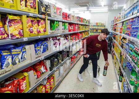 Malaga Spanien, Andalusien, El Molinillo Capuchinos Nachbarschaft, Supermarkt Inneres Snack Gang junger Erwachsener Mann männlicher Einkäufer, der sich beugt, Getränke-Bot zu picken Stockfoto