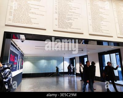 London, Großbritannien - 02. Februar 2026: Besucher in Mänteln spazieren durch ein modernes Londoner Museum, die Lobby der National Gallery, vorbei an Ausstellungstafeln und Glastüren. Stockfoto