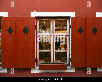 Rote Holzläden und Schaufenster mit Kunsthandwerk in einem mittelalterlichen Gebäude in der Altstadt von Tallinn, Estland Stockfoto