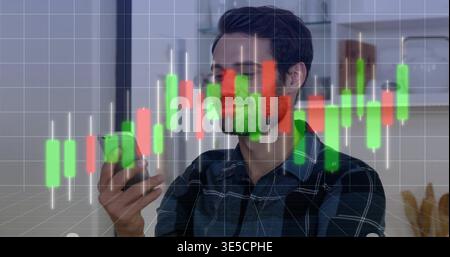Überwachen Sie Mann in dunklem kariertem Hemd, und überprüfen Sie das Smartphone, während Sie zu Hause Kerzendiagramm sehen Stockfoto