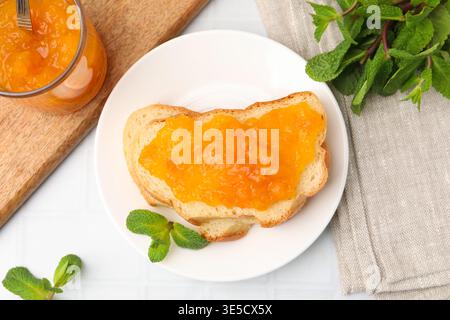Toasts mit süßer Marmelade und Minze auf weißem Tisch, flach gelegt Stockfoto