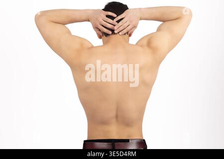 Rückansicht eines muskulösen Mannes mit Händen auf dem Kopf Stockfoto