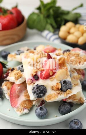 Leckere Joghurtrinde mit Beeren und Müsli auf dem Lichttisch, Nahaufnahme Stockfoto