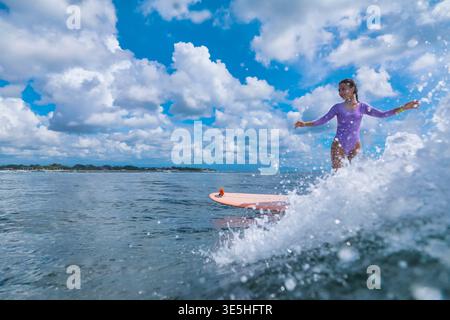 Junge Frau, Die Longboard-Manöver Auf Rolling Swell Übt, Fokussierte Technische Sitzung Mit Präziser Fußarbeit, Stockfoto