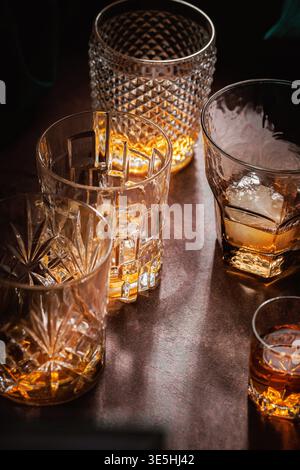 Whiskey-Gläser mit Eis auf Bartisch dramatisches Licht Stockfoto