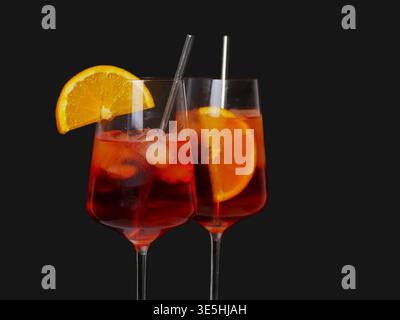 Erfrischende Aperol Aperitif-Getränke in Gläsern mit Eis und Orangengarnitur, perfekt für eine Sommerfeier. Stockfoto