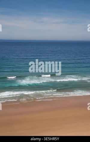 Sandstrand mit sanften Atlantikwellen unter Dem blauen Himmel auf dem Fishermans Trail, Portugal Stockfoto
