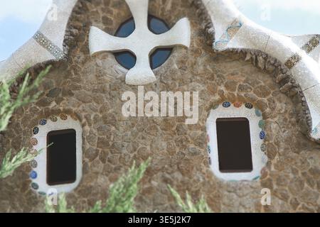 Eine Nahaufnahme der Fassade eines Gebäudes im Park Güell, Barcelona, entworfen von Antoni Gaudi. Das Bild zeigt die rustikalen Steinmauern, eine große wh Stockfoto