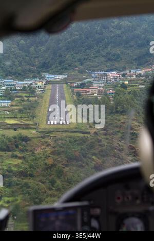 Blick aus nächster Nähe auf Luklas legendäre Start- und Landebahn am Hang mit den Bergen im Himalaya. Stockfoto