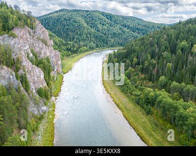 Drohnenfoto, das dramatische felsige Klippen und Nadelwälder entlang des gewundenen Flusses zeigt und atemberaubende Landschaften für Rafting in Kuzbass schafft, selektiv f Stockfoto