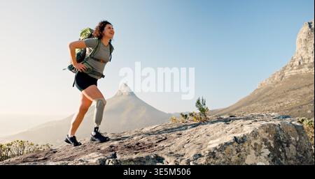 Glückliche Frau, Wandern und Rucksack mit Beinprothese auf Bergfelsen für Outdoor-Übungen. Wanderer, Reise oder weibliche Person mit Behinderung auf Klippen Stockfoto