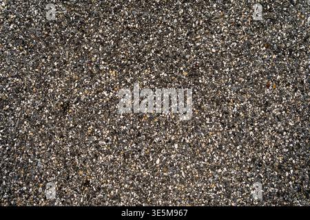 Raue Asphaltstruktur. Schotter und Asphaltflächen erzeugen einen detaillierten Straßenhintergrund. Abstrakte urbane Steinstruktur. Nahaufnahme des Asphaltbelags mit Stockfoto