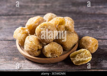 Süße konservierte Jujube-Früchte in einer Holzschale auf einer rustikalen Tischoberfläche Stockfoto