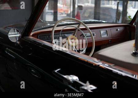 Shanghai 2. märz 2026 Oldtimer-Innenraum mit weißem Lenkrad, poliertem hölzernem Armaturenbrett und Chrom-Tachometer, das an Nostalgie erinnert Stockfoto
