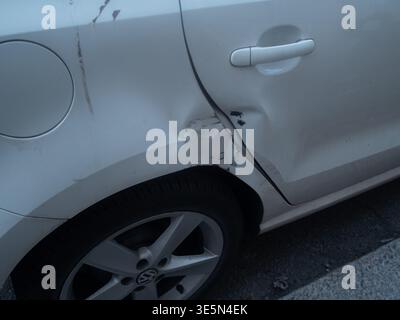 Lombardei, Italien - 15. März 2026 Nahaufnahme einer verbeulten und zerkratzten weißen Fahrzeugtür, die die Auswirkungen auf die Karosserie des Fahrzeugs unterstreicht Stockfoto